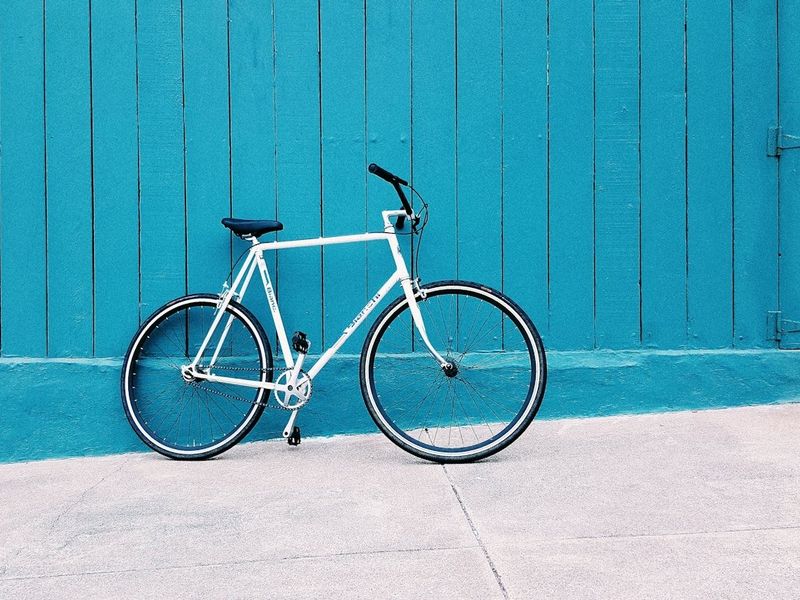 Bicicleta encostada em parede azul